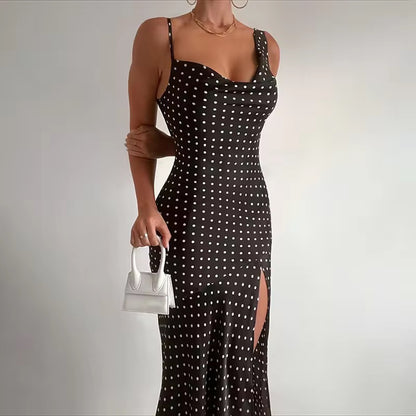 Black polka dot dress with a white handbag on a plain background