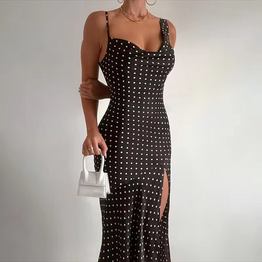 Black polka dot dress with a white handbag on a plain background