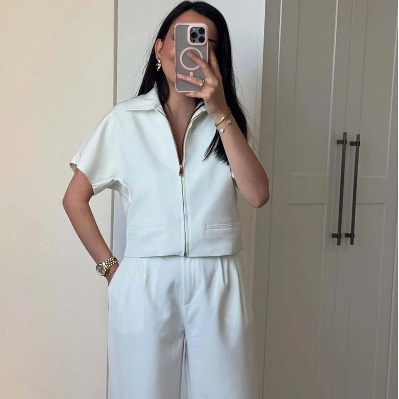 Person wearing a light blue outfit taking a mirror selfie.