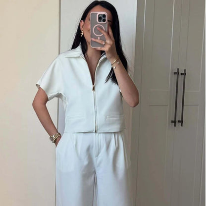 Person wearing a light blue outfit taking a mirror selfie.