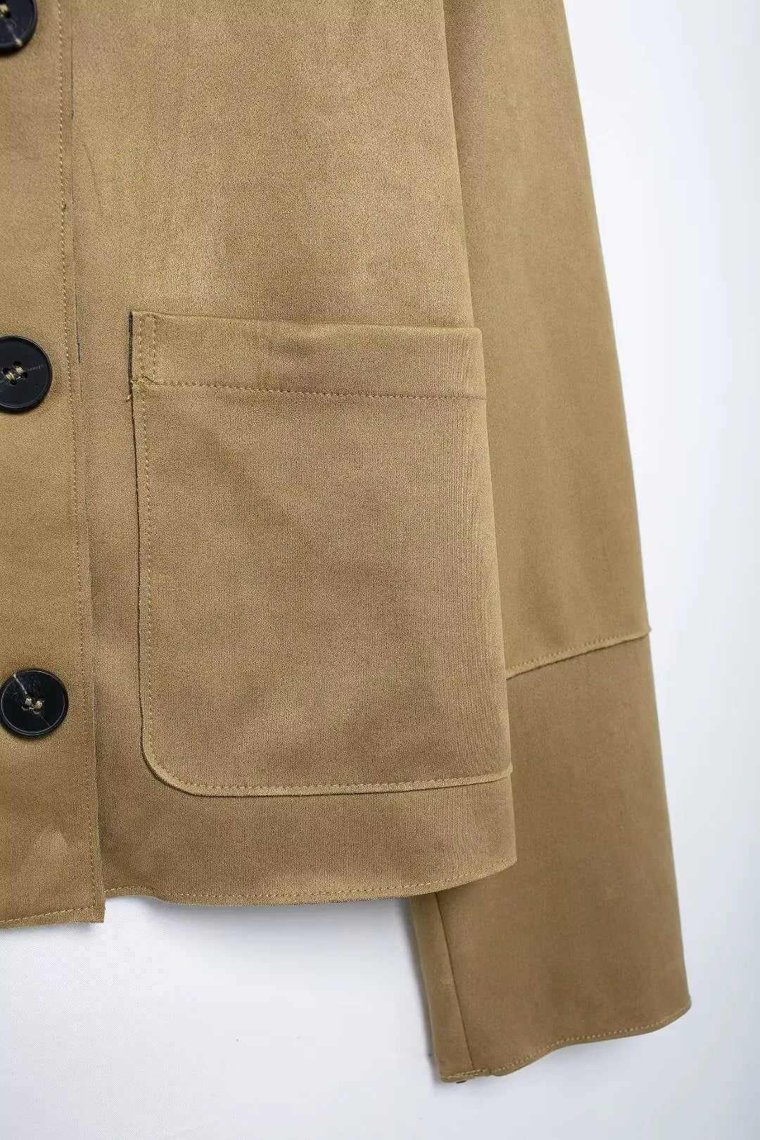 Close-up of a beige jacket with button details on a white background
