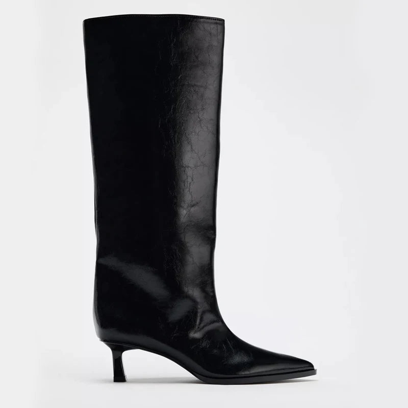 Black knee-high boot on a light gray background