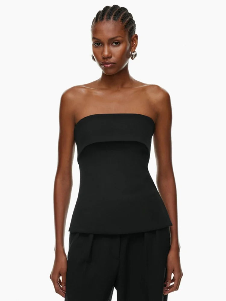 Woman wearing a black strapless top and black pants on a white background
