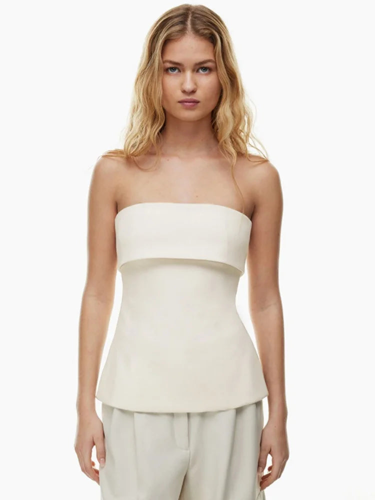 Woman wearing a strapless white top and light pants on a white background