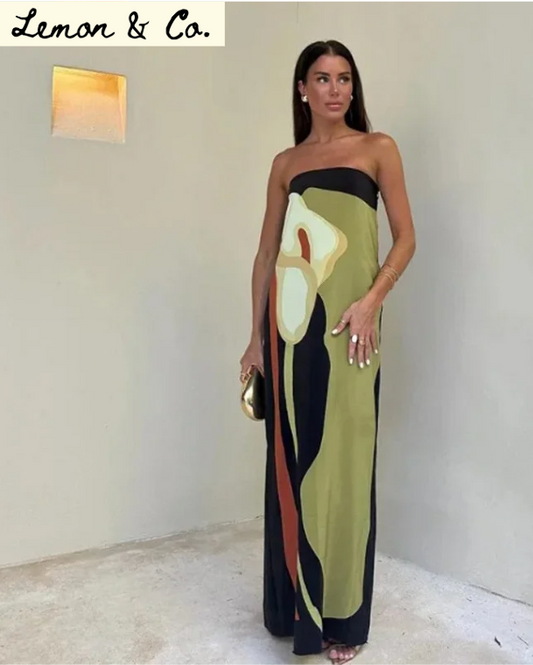 Woman wearing a strapless dress with abstract design in a minimal indoor setting.