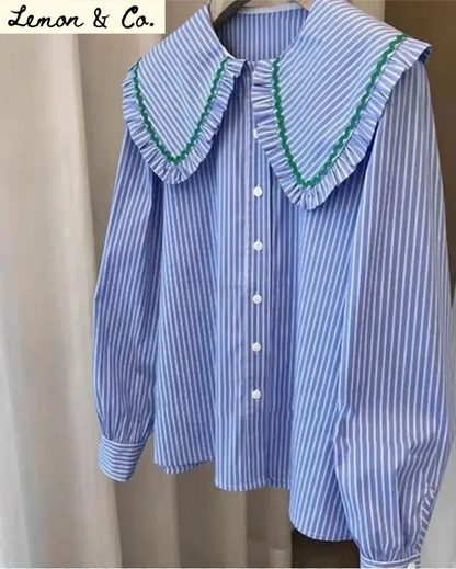 Blue and white striped shirt with ruffled collar on a hanger, brand 'Lemon & Co.' visible.