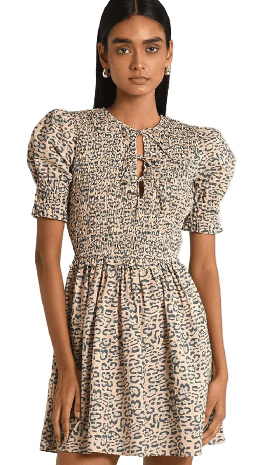 Woman wearing a leopard print dress with puff sleeves on a white background