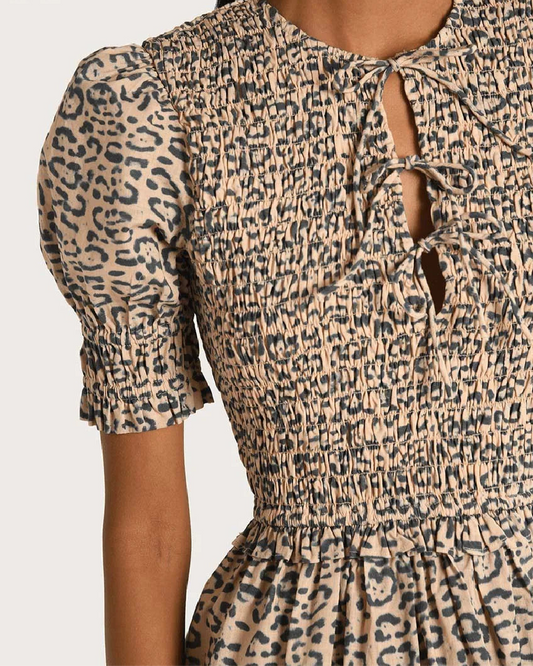 Leopard print dress with puff sleeves on a plain background